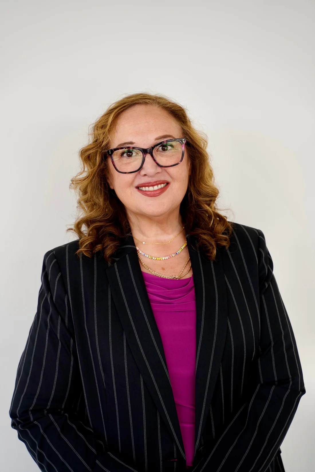 Jessica Hernandez in a dark pinstripe suit